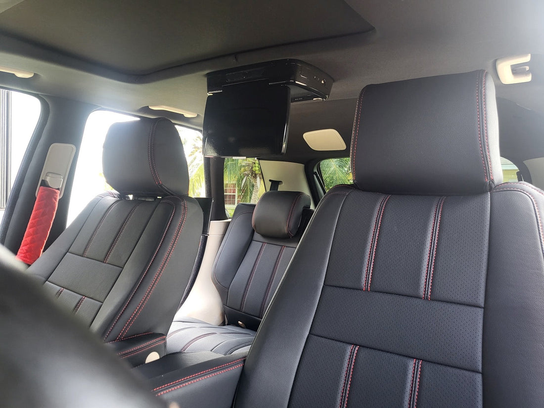 Front seats of Land Rover Range Rover Sport 2010 with black artificial nappa leather seat covers featuring red stitching and red quilted seatbelt covers