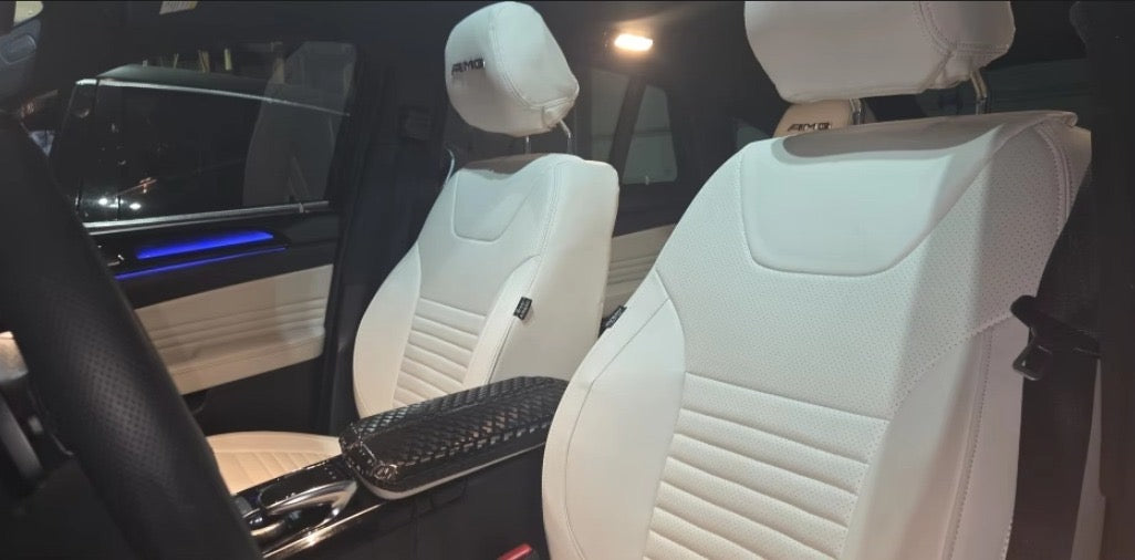 Front seats of a Mercedes Benz GLE covered in white artificial nappa leather seat covers with detailed stitching