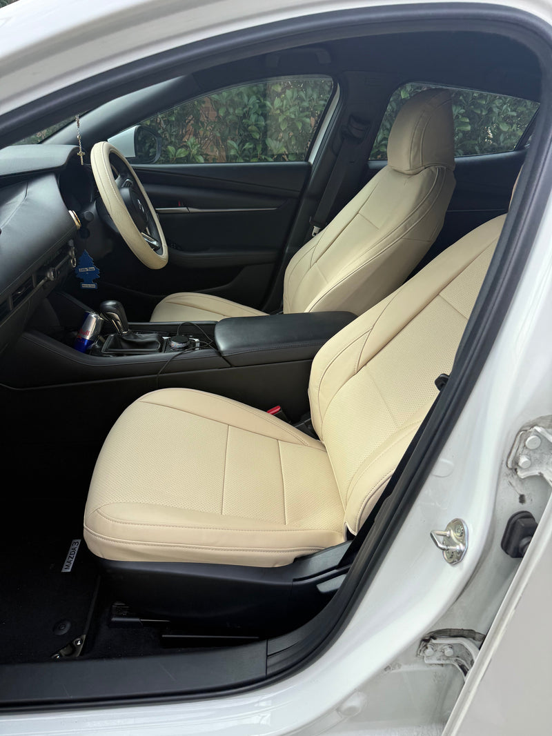 Close-up side view of custom-fit beige artificial nappa leather seat cover on Mazda 3 hatchback front passenger seat