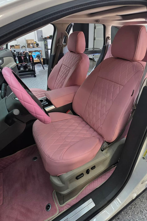 Front seats of a 2013 Ford Edge covered in light pink artificial Nappa leather seat covers with diamond stitching and matching floor mats